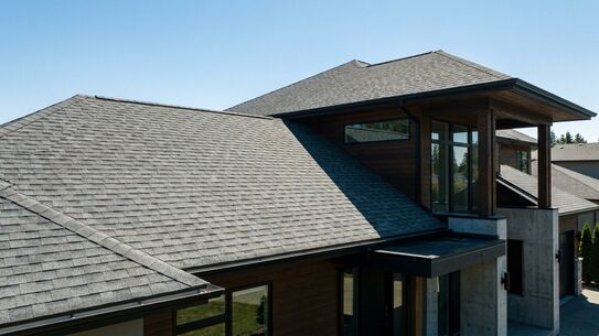 Newly installed asphalt shingle roof on a modern home
