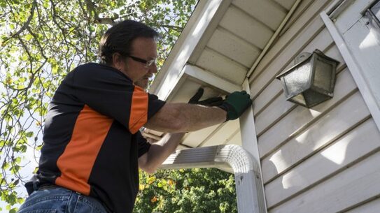 Local siding contractor working on the trim and soffit of a home