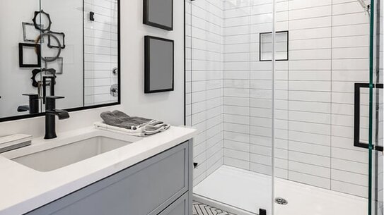 Remodeled bathroom with tiled walls, a patterned floor and a modern vanity
